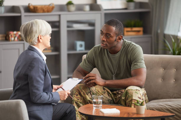 African man sitting on sofa and consulting with his psychologist during visit