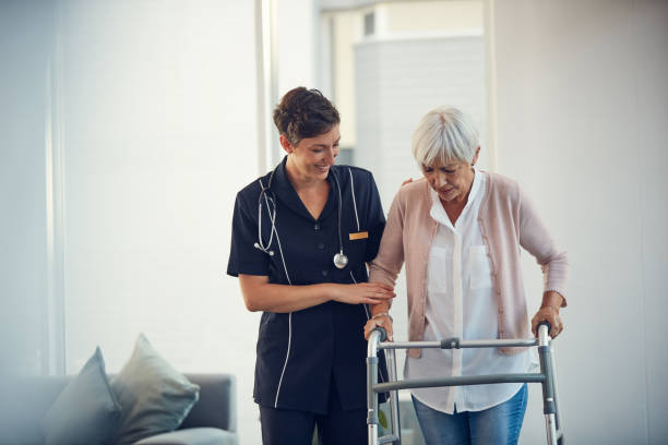 Cropped shot of a young nurse assisting a senior woman walk using a walker in a nursing home