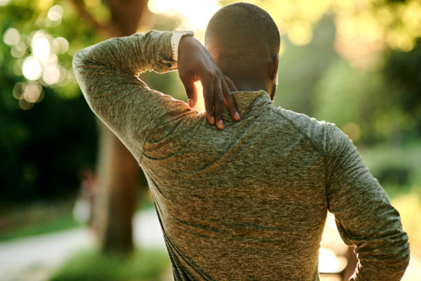 Rearview shot of a sporty young man suffering from a sports injury outdoors