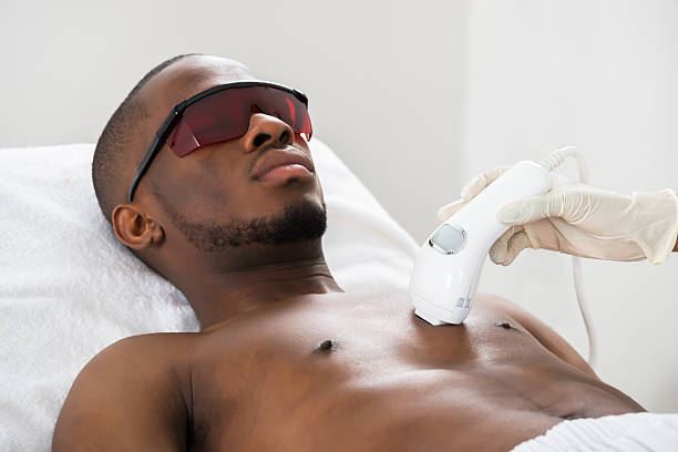 Therapist Giving Laser Epilation On Young African Man's Chest